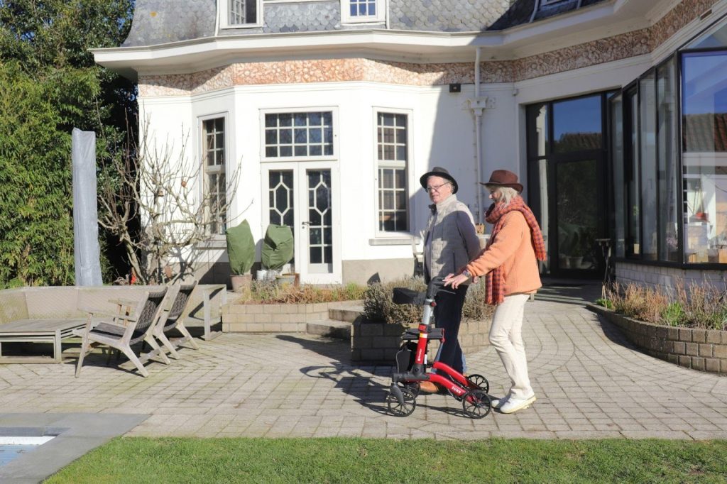  A senior couple enjoying a walk outdoors in a sunny garden while touring Thornhill retirement residences to experience the community atmosphere firsthand.